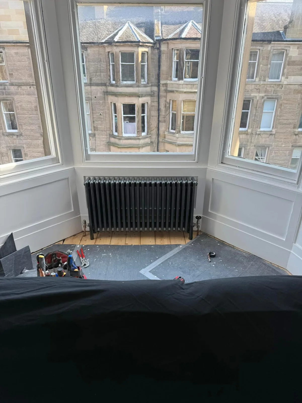 Column radiator beneath a bay window