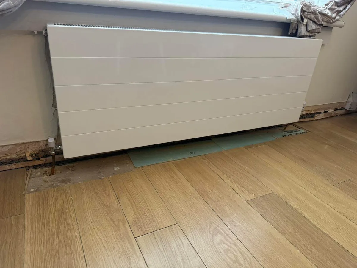White panel radiator beneath a window
